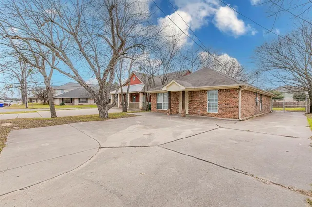 a front view of a building with large trees