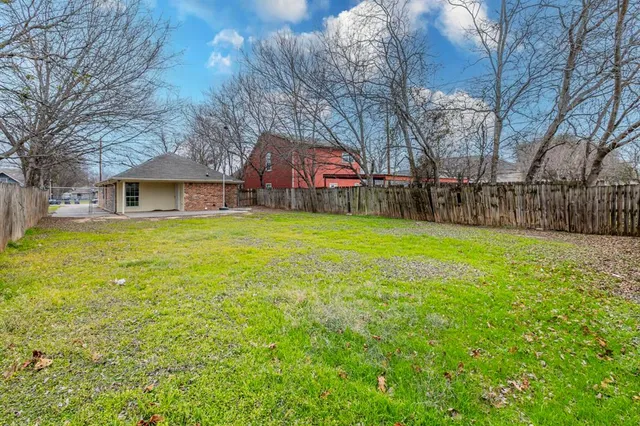 a view of a house with a yard and trees