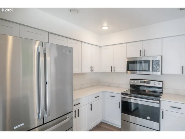a kitchen with stainless steel appliances a refrigerator stove and microwave