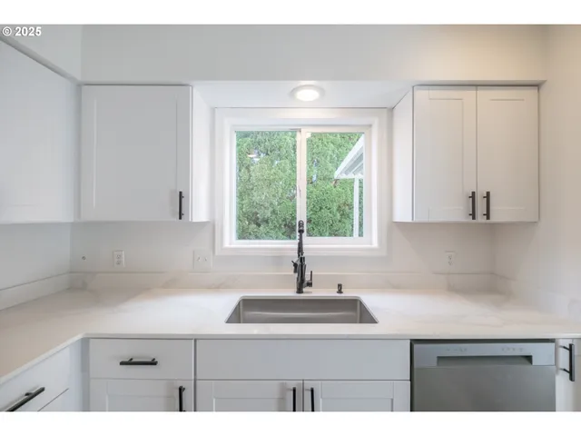 a kitchen with a sink and large window