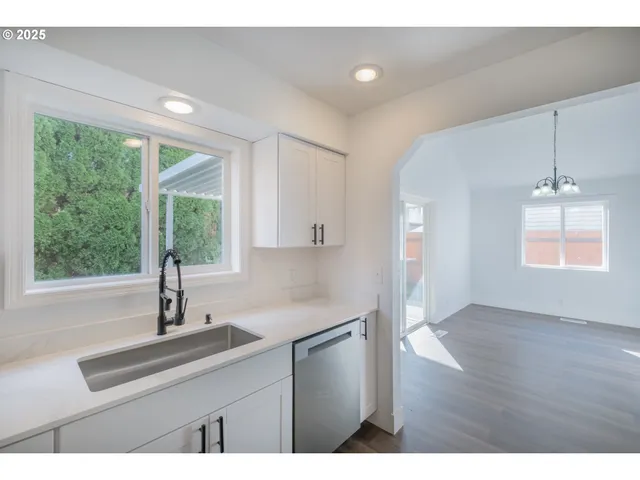 a kitchen with a sink a window and wooden floor
