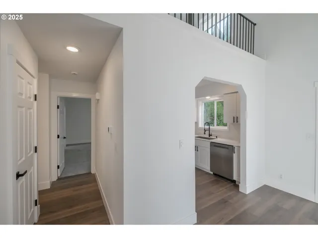 a view of hallway with kitchen and wooden floor