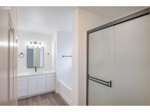 a bathroom with a sink a mirror and shower