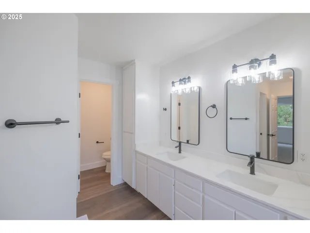 a bathroom with a double vanity sink mirror and shower
