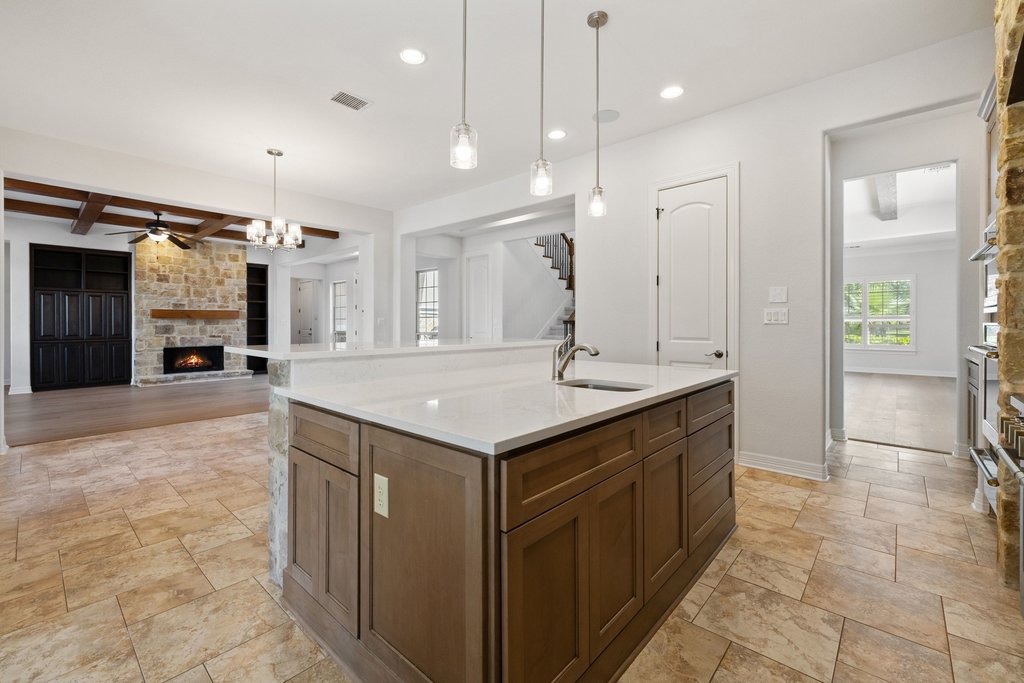 109 Largo Cove Austin, TX 78734 - Photo 14 of 40 A well-appointed kitchen island with gleaming counters anchors an open-concept living space.