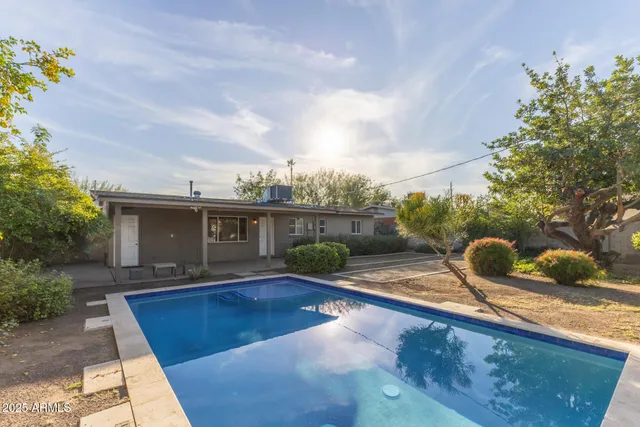 a view of a house with backyard and sitting area