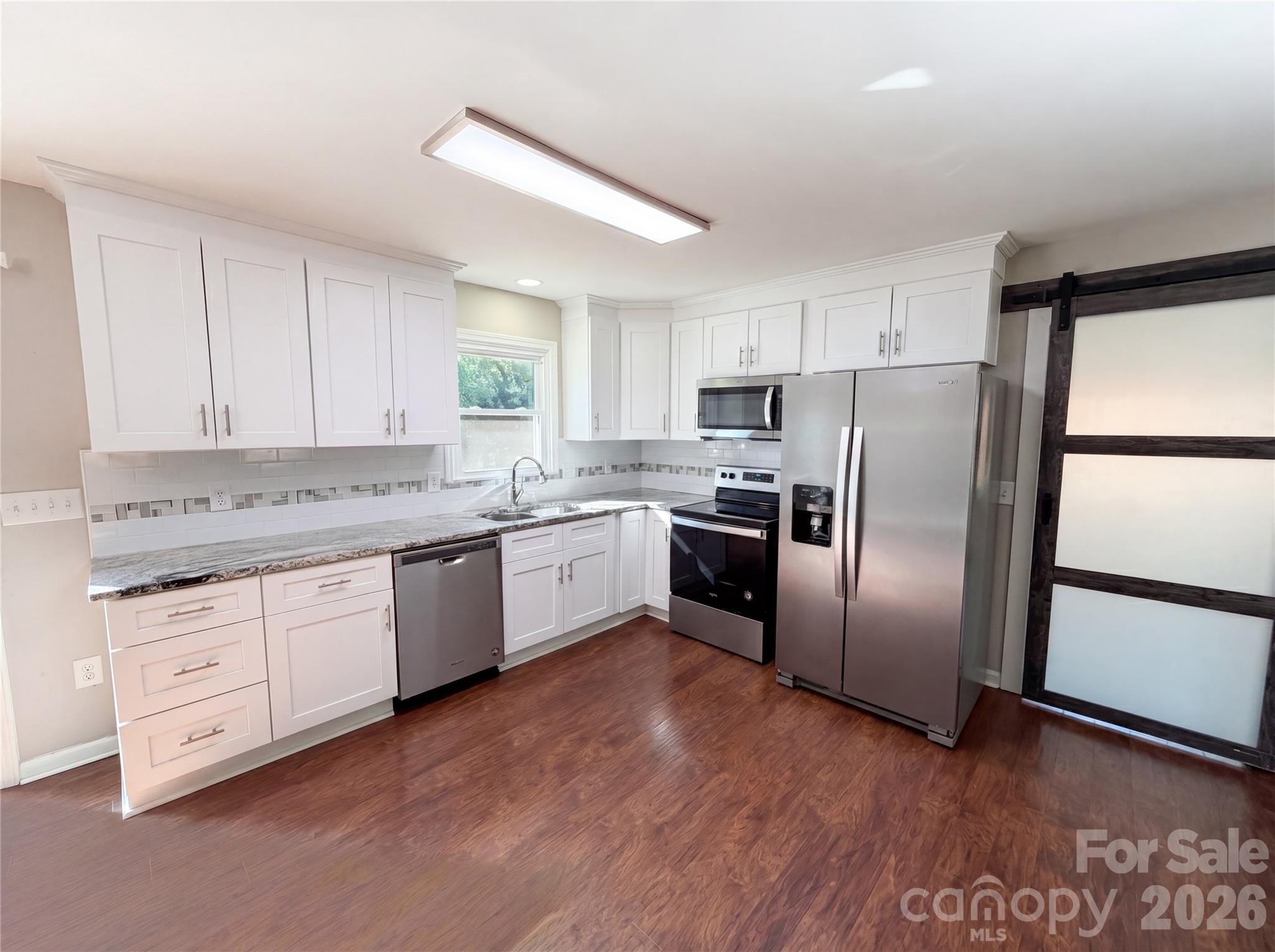 2375 Saw Road China Grove, NC 28023 - Photo 6 of 18 a kitchen with granite countertop stainless steel appliances a refrigerator sink and microwave