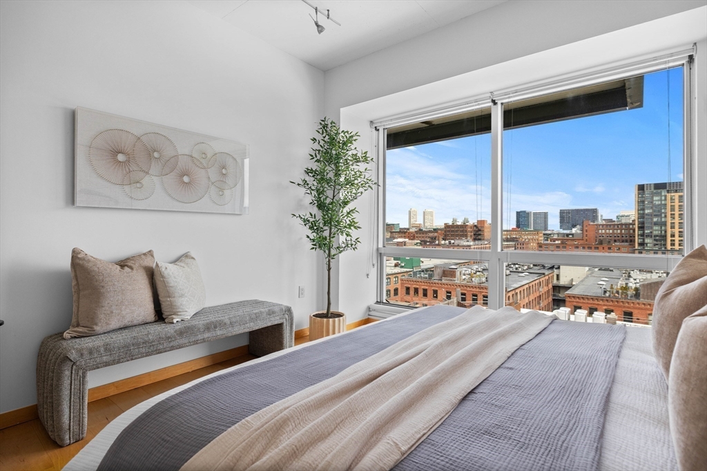 25 Channel Center Street, Unit 1102 Boston, MA 02210 - Photo 21 of 28 a bedroom with furniture and a large window