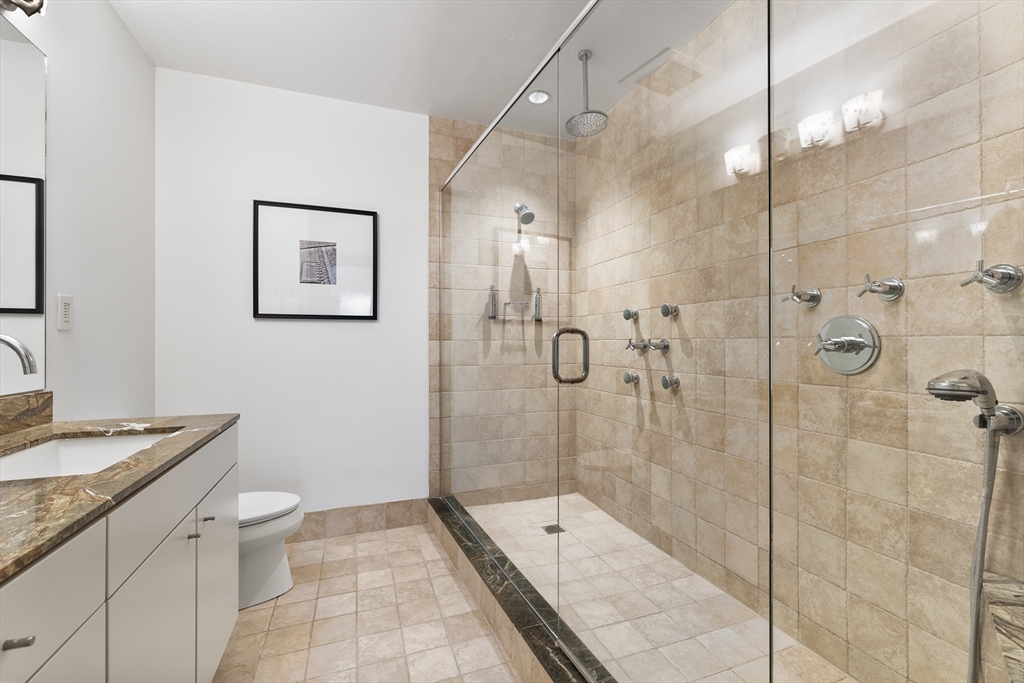 25 Channel Center Street, Unit 1102 Boston, MA 02210 - Photo 23 of 28 a bathroom with a double vanity sink toilet and shower