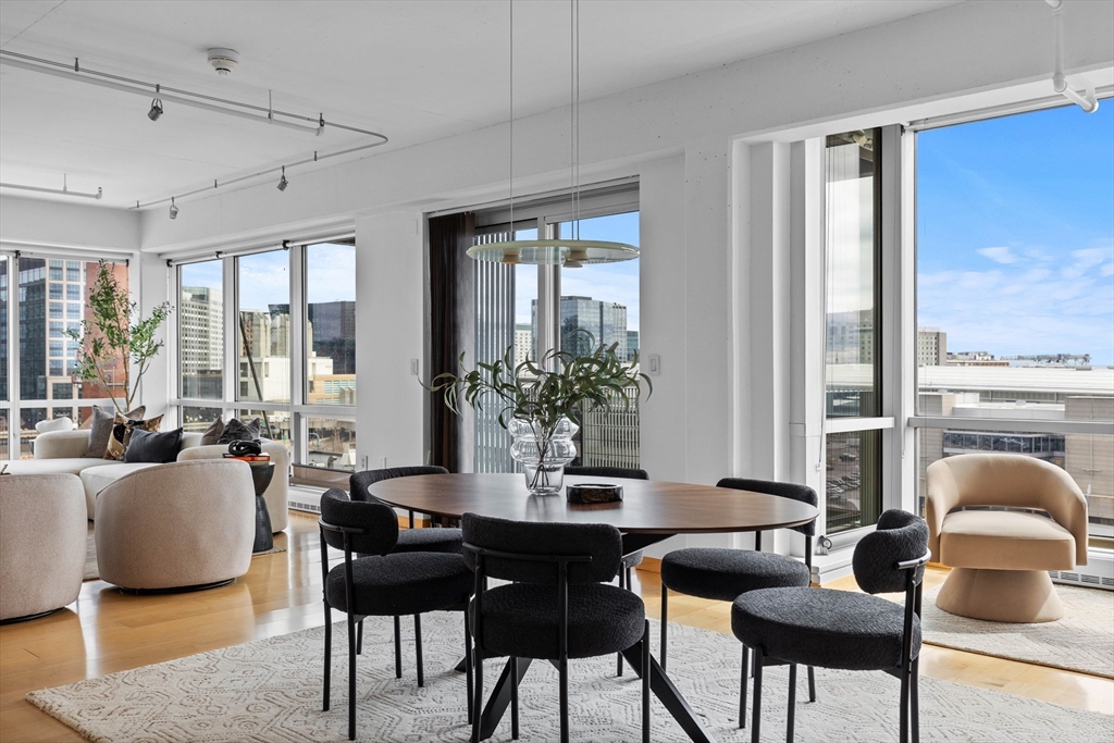 25 Channel Center Street, Unit 1102 Boston, MA 02210 - Photo 7 of 28 a dining room with furniture a large window and wooden floor