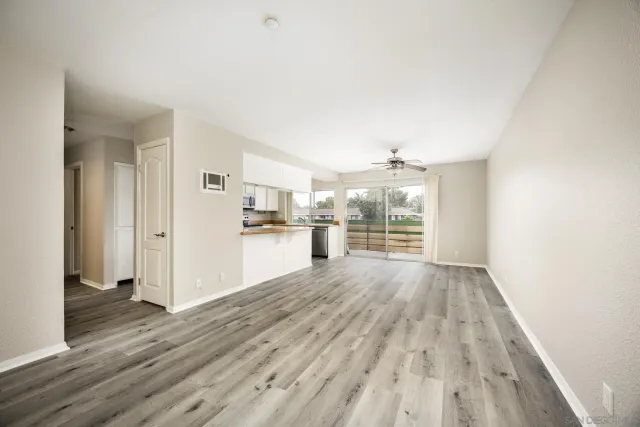 a view of a kitchen with wooden floor and a refrigerator