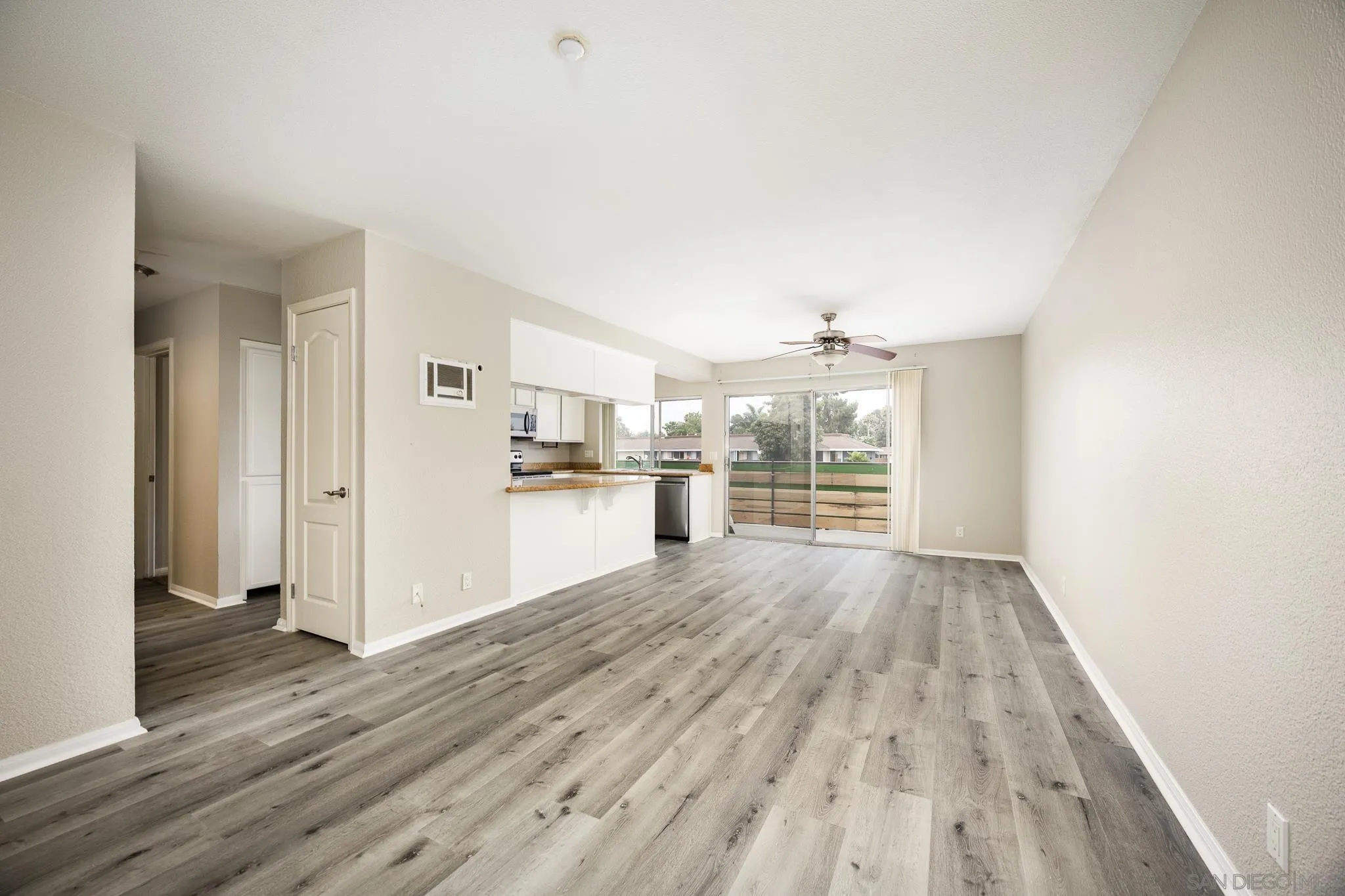 615 Fredricks Avenue, Unit 134 Oceanside, CA 92058 - Photo 13 of 40 a view of a kitchen with wooden floor and a refrigerator