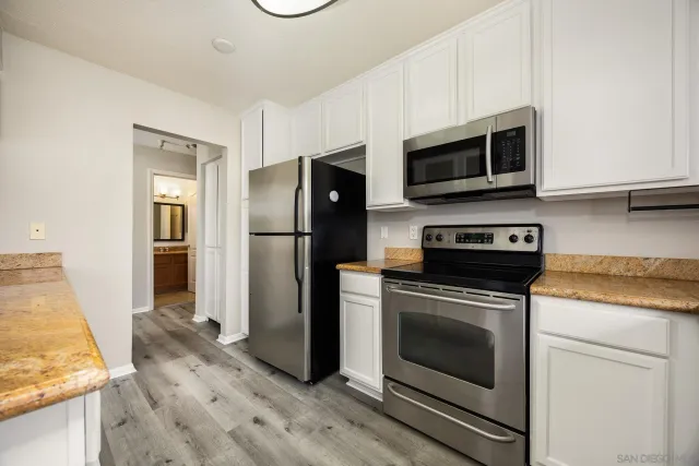 a kitchen with stainless steel appliances granite countertop a refrigerator stove and microwave