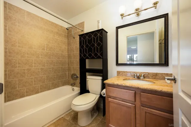 a bathroom with a toilet sink vanity tub and shower
