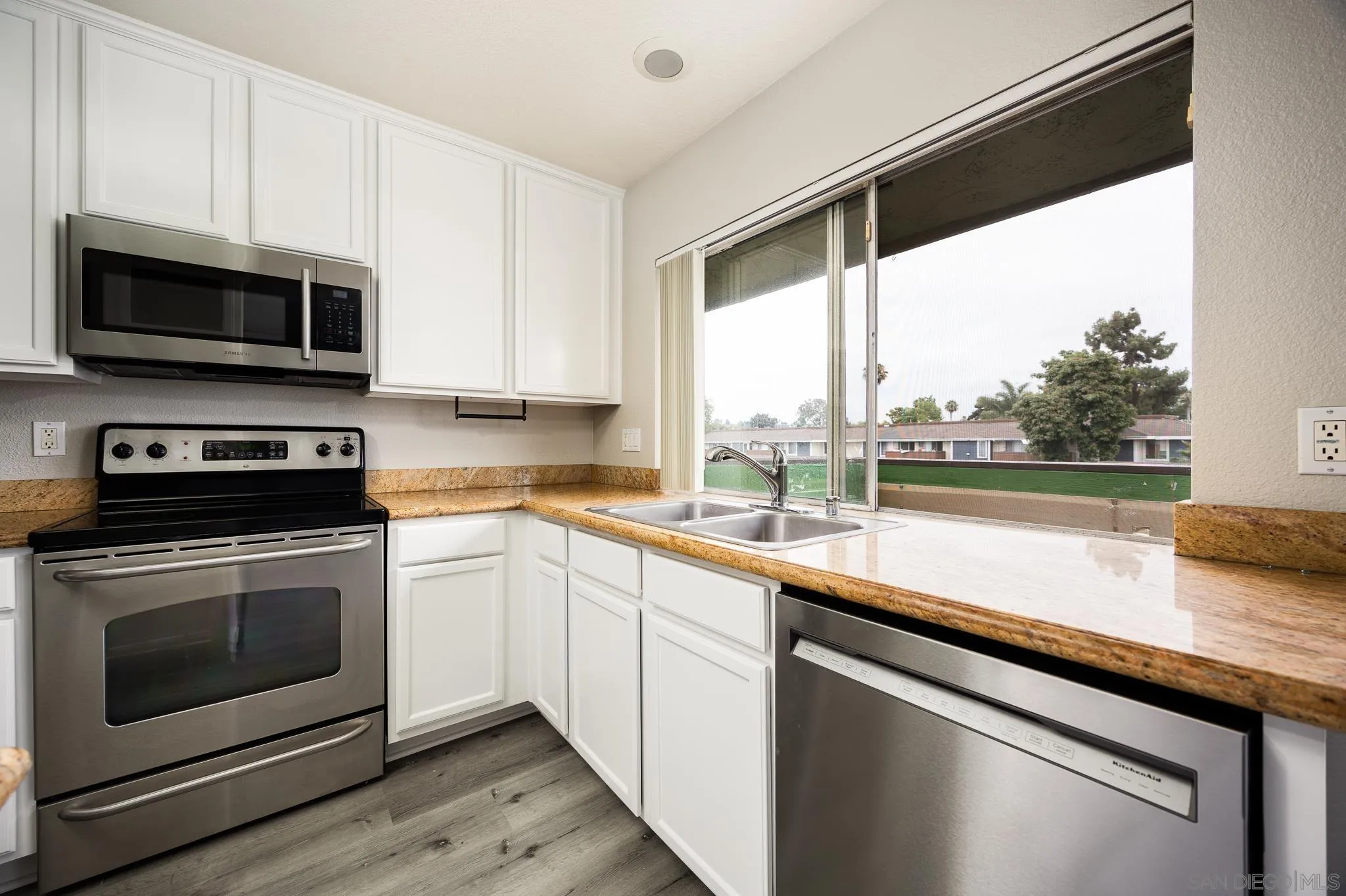 615 Fredricks Avenue, Unit 134 Oceanside, CA 92058 - Photo 7 of 40 a kitchen with stainless steel appliances a stove a sink and a microwave