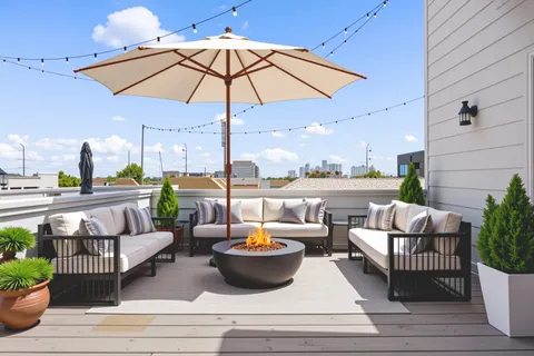 an outdoor living space with furniture and umbrella