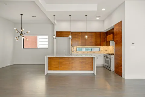 a view of kitchen with kitchen island a sink stainless steel appliances and cabinets