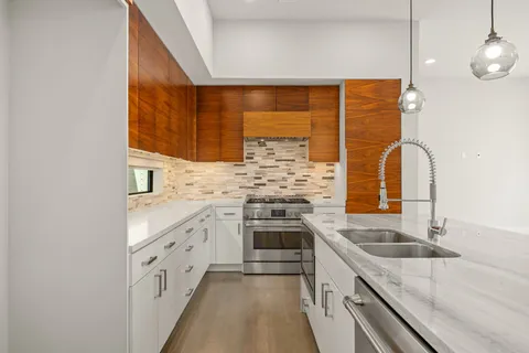 a kitchen with granite countertop a sink and a stove top oven