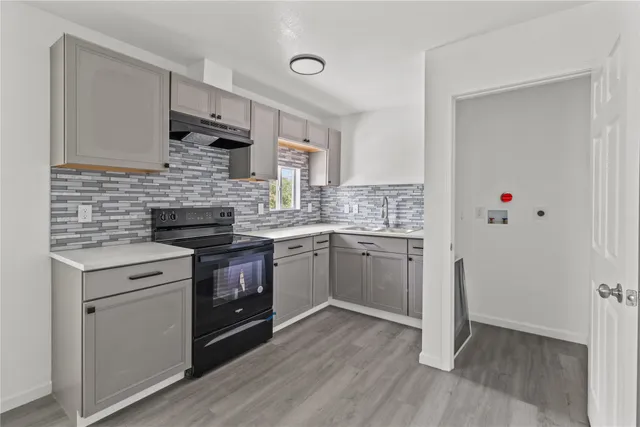 a kitchen with a stove sink and cabinets