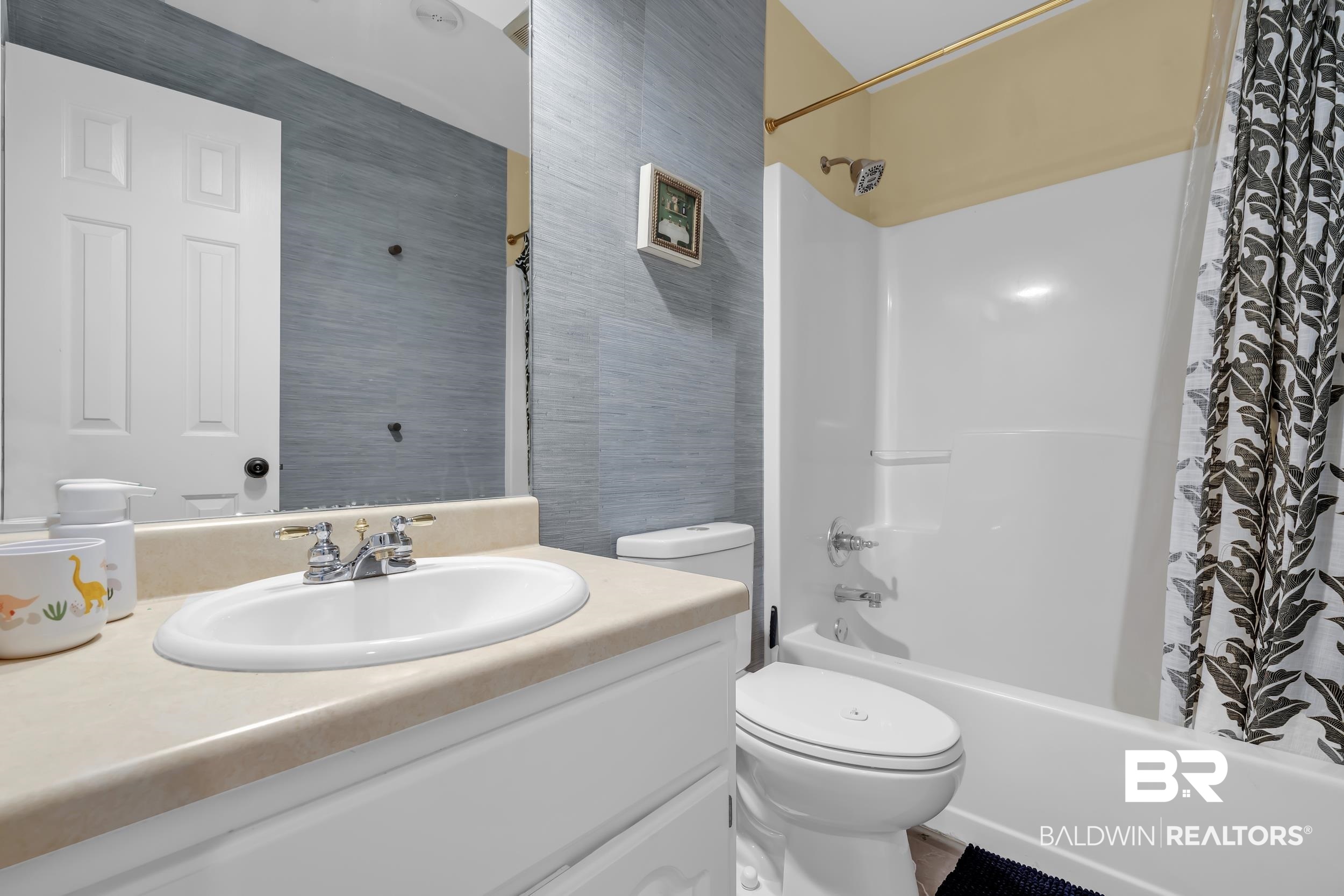 509 Loblolly Court Foley, AL 36535 - Photo 20 of 26 Bathroom featuring a white vanity with an oval basin, a shower-over-tub combination with a white surround, and blue-toned wall tile