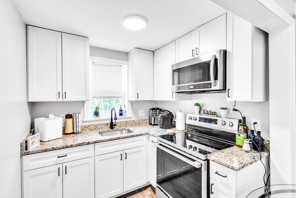306 Berlin Road Marlborough, MA 01752 - Photo 24 of 36 a kitchen with stainless steel appliances a stove a sink a microwave and cabinets