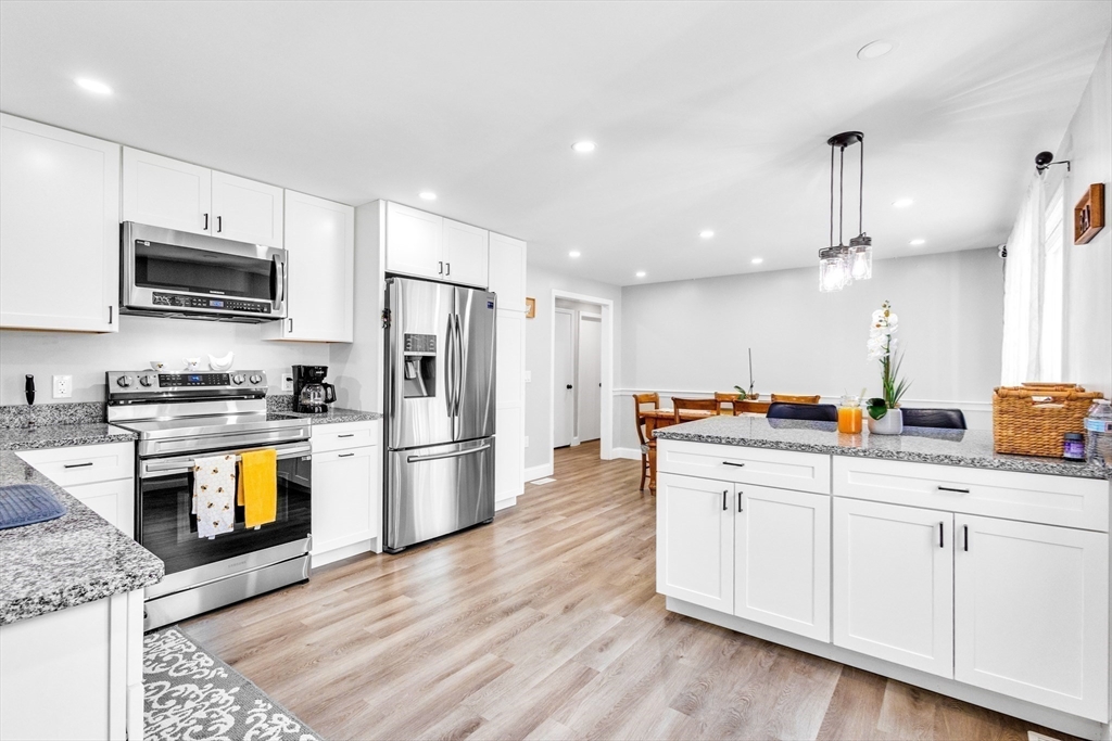 306 Berlin Road Marlborough, MA 01752 - Photo 7 of 36 a kitchen with stainless steel appliances kitchen island granite countertop a refrigerator a stove top oven a sink dishwasher and white cabinets with wooden floor