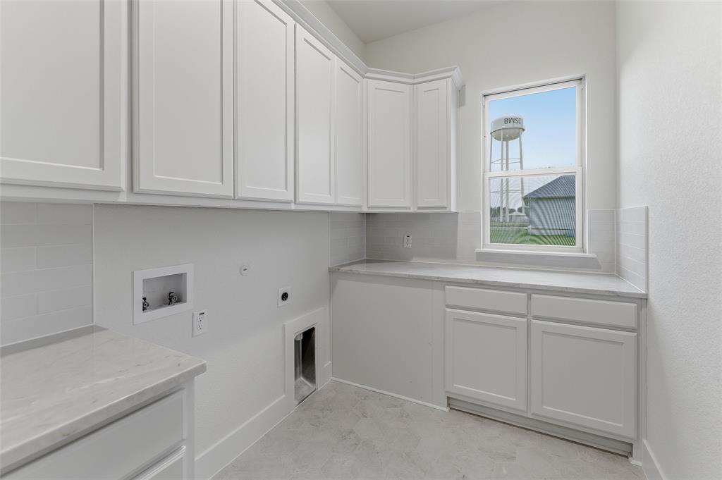 2208 Continent Court Krum, TX 76249 - Photo 9 of 26 Utility room featuring extensive white shaker-style cabinetry, light-toned countertops, subway tile backsplash, and a window providing natural light