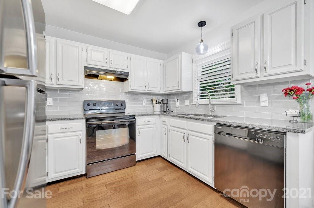 3080 Point Clear Drive Tega Cay, SC 29708 - Photo 6 of 23 a kitchen with granite countertop white cabinets and white appliances
