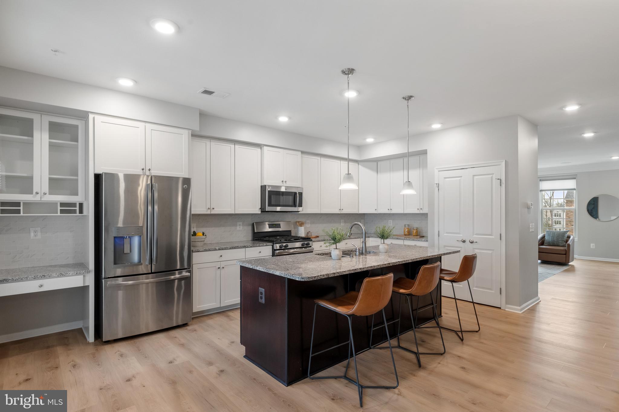 13635 Rockingham Lane Gainesville, VA 20155 - Photo 3 of 56 a kitchen with stainless steel appliances granite countertop a table chairs sink refrigerator and microwave