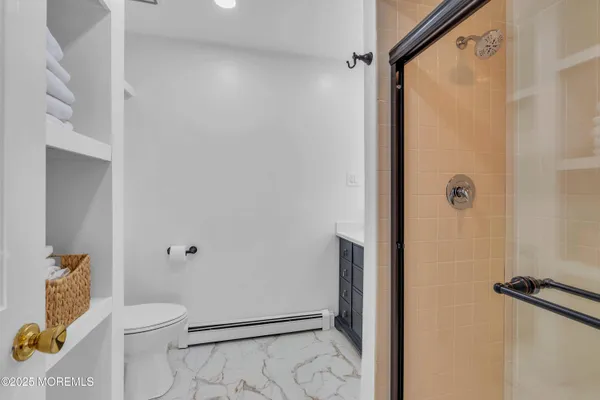 a bathroom with a granite countertop shower and a toilet