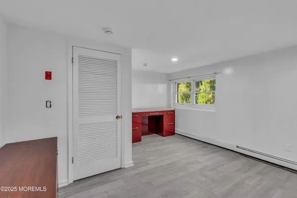 an empty room with a window and a dresser