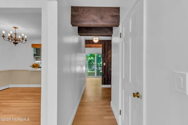 a view of a hallway with wooden floor and entryway