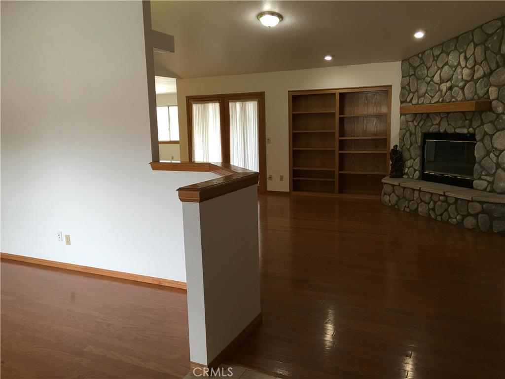 20231 Wadena Road Apple Valley, CA 92308 - Photo 5 of 20 wooden floor in an empty room with a fireplace