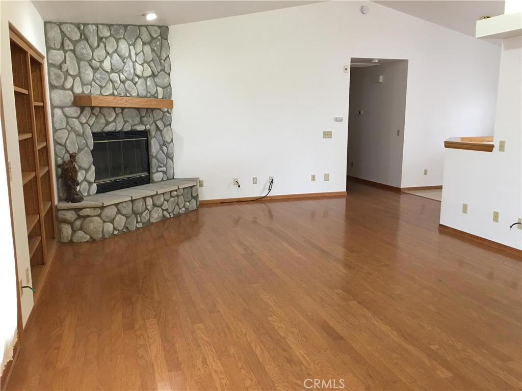 20231 Wadena Road Apple Valley, CA 92308 - Photo 6 of 20 an empty room with wooden floor and fireplace