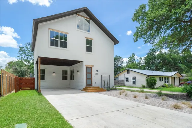 a front view of house with a yard and green space