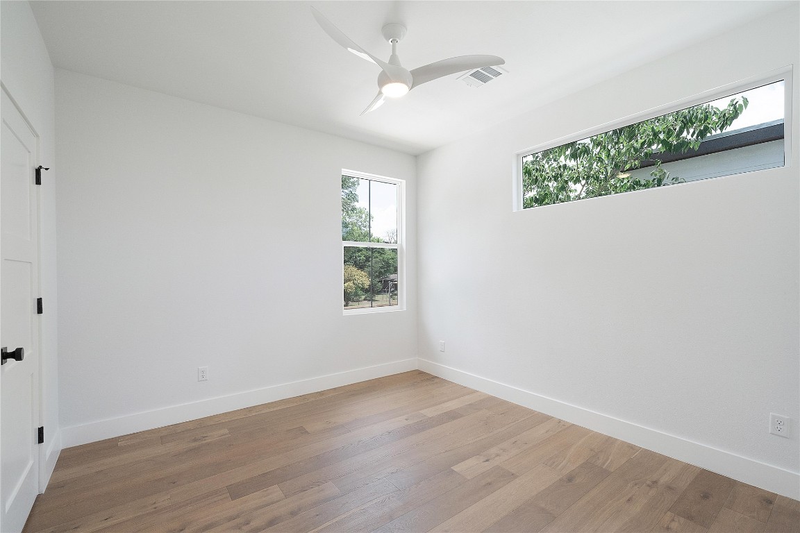 4805 Enchanted Lane, Unit 1 Austin, TX 78745 - Photo 20 of 29 an empty room with wooden floor and windows