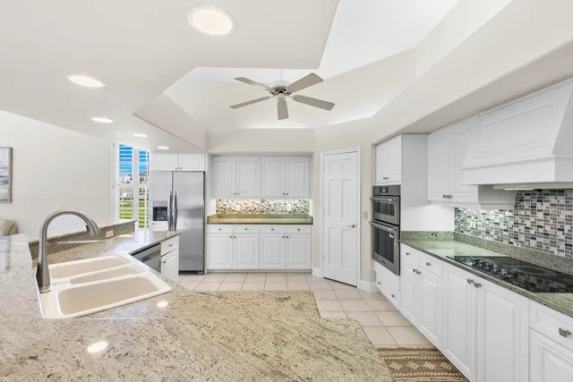 a kitchen with granite countertop a sink and stainless steel appliances