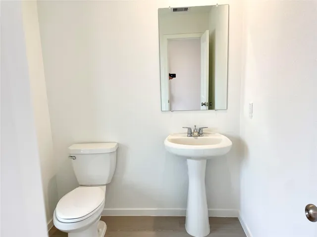 a bathroom with a toilet a sink and a mirror