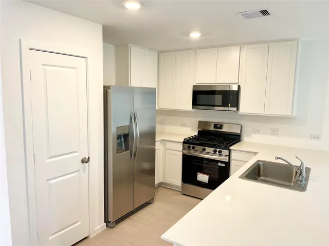 a kitchen with a refrigerator stove and microwave