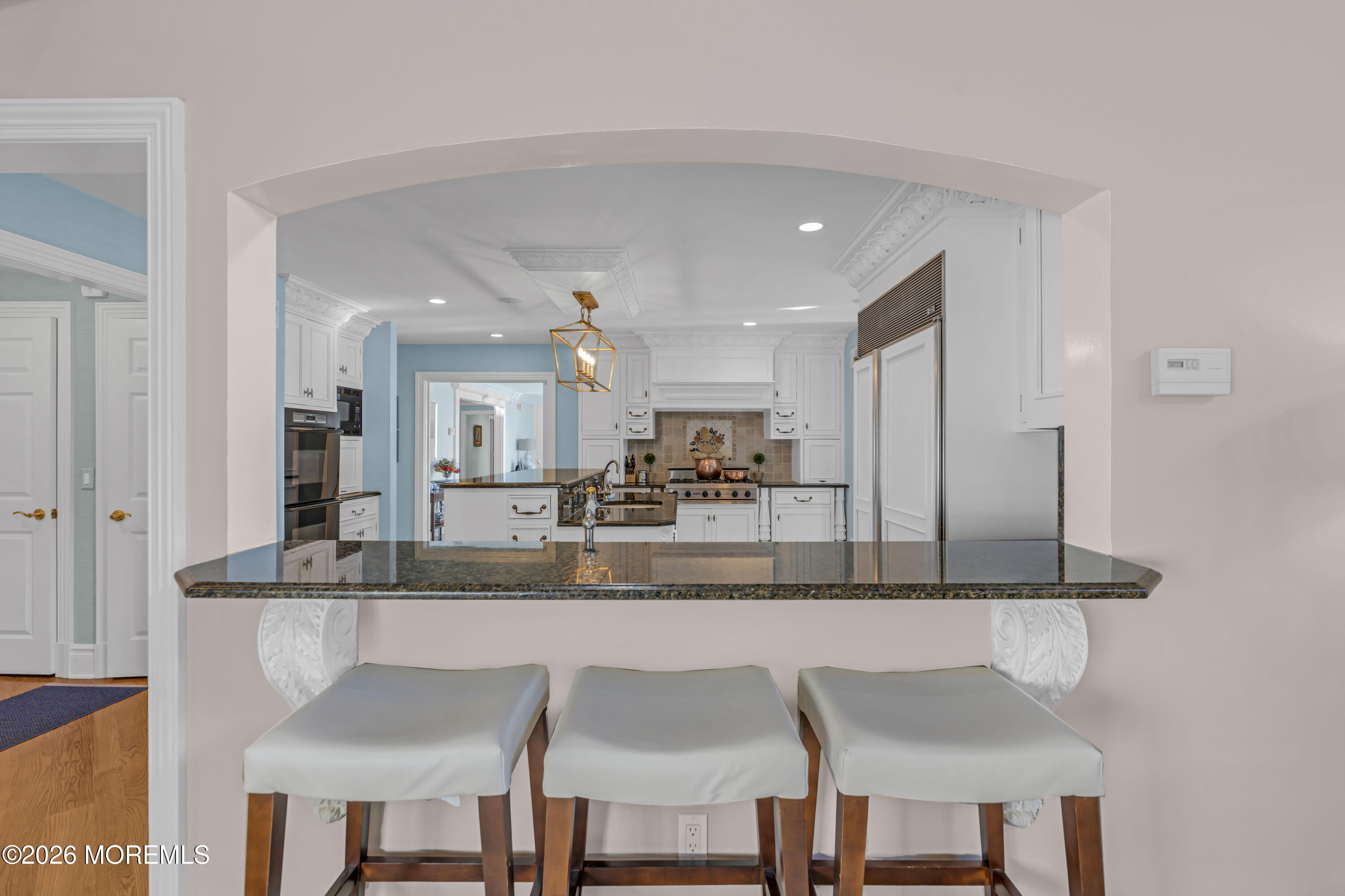 942 Navesink River Road Middletown, NJ 07760 - Photo 18 of 42 a kitchen with stainless steel appliances granite countertop a dining table chairs and a refrigerator