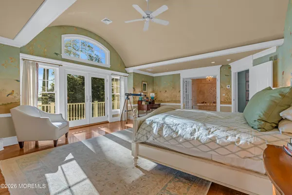 a bed sitting in a spacious bedroom next to a window