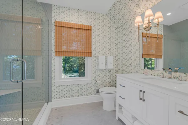 a bathroom with a sink a toilet and shower