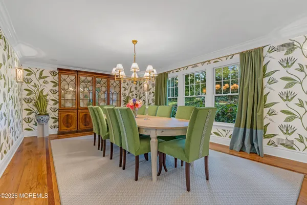a view of a dining room with furniture a chandelier and a rug