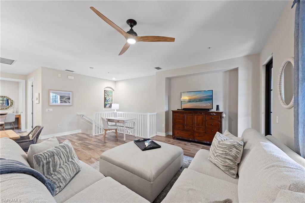 9076 Rialto Street, Unit 6204 Naples, FL 34113 - Photo 6 of 50 Open-concept living space featuring wood-finish flooring, a modern ceiling fan, and a built-in media niche. NEW TILE FLOOR (2018)
