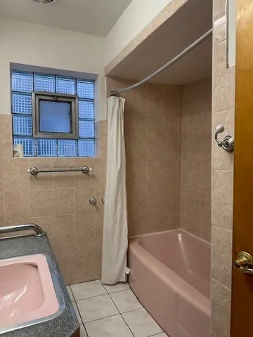 a bathroom with a tub shower and vanity