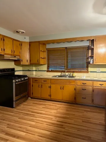 a kitchen with stainless steel appliances kitchen island granite countertop a stove a sink and a microwave