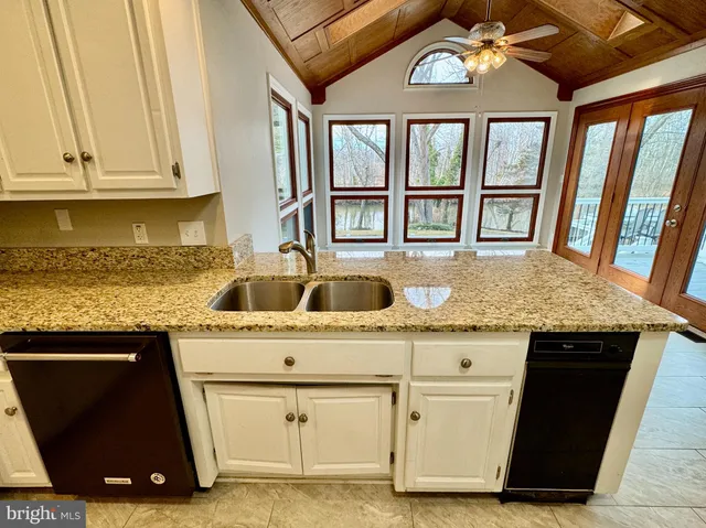 a kitchen with stainless steel appliances granite countertop a sink stove and cabinets