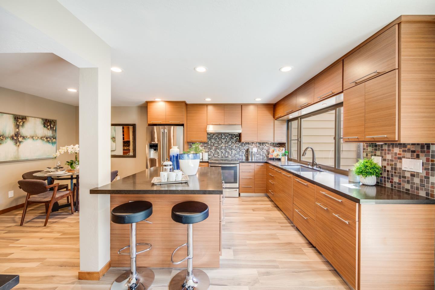 22832 Longdown Road Cupertino, CA 95014 - Photo 10 of 41 a kitchen with stainless steel appliances kitchen island granite countertop a kitchen island and chairs in it