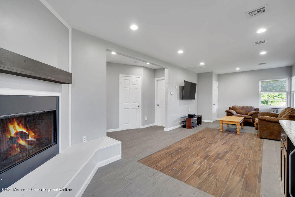 4 Nolan Road Morganville, NJ 07751 - Photo 11 of 46 a living room with furniture a fireplace and a flat screen tv