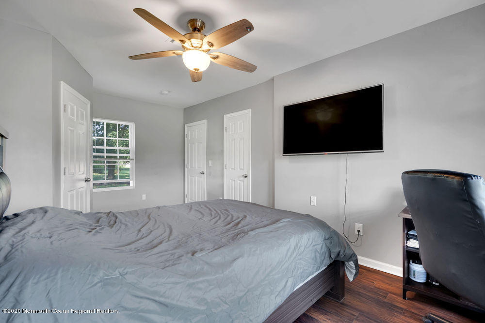 4 Nolan Road Morganville, NJ 07751 - Photo 29 of 46 a bedroom with a bed a flat screen tv and a chandelier